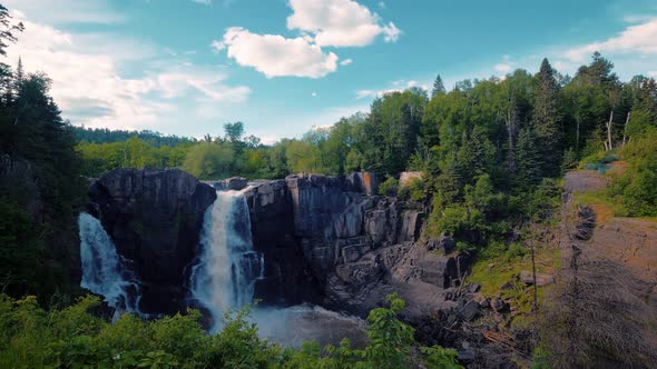 Forest waterfall over a cliff side at the Grand Portage high falls waterfall along the pigeon River alt
