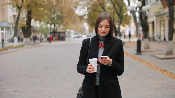 Woman Checks Mail, Looks at News, Chats on the Phone and Drinks Coffee on the Street alt