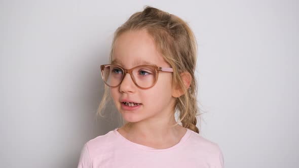 A Little Girl is Actively Telling Something and Looking at the Camera alt