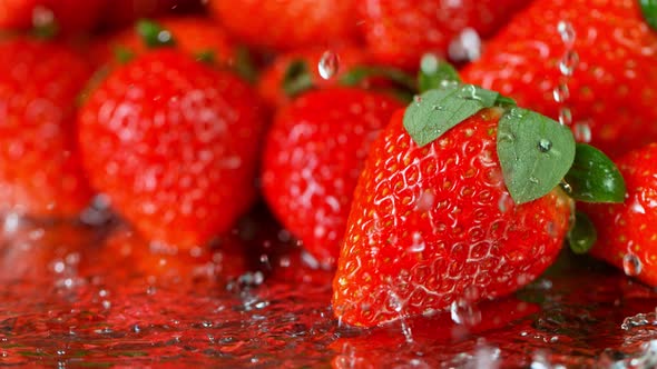 Super Slow Motion Shot of Water Splashing on Fresh Strawberries at 1000Fps alt
