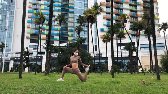 Woman on the Face Mask Doing Workout in the City