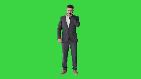 Businessman Using Speak Activate Virtual Digital Voice Assistant on Smartphone on a Green Screen alt