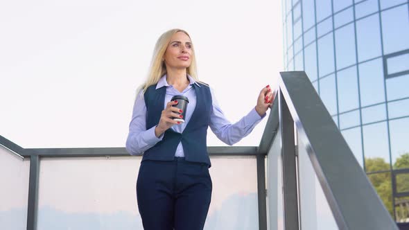 Portrait of 50 Years Businesswoman Standing Outside a Modern Corporate Building with Coffee Cup alt