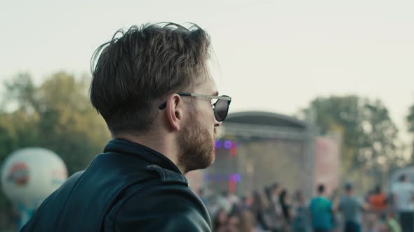 Rear view of  young caucasian man  on music festival looking at the stage. Shot with RED helium came alt