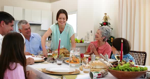 Mother bringing turkey to dinner table for christmas 4k alt