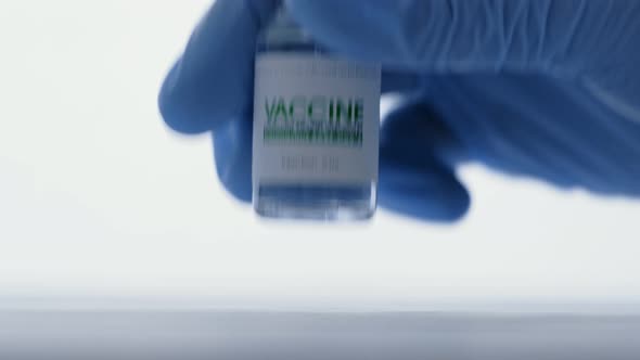 Doctor in Medical Glove Takes Vial of Vaccine for Injection for COVID19 Coronavirus Cure in Research alt