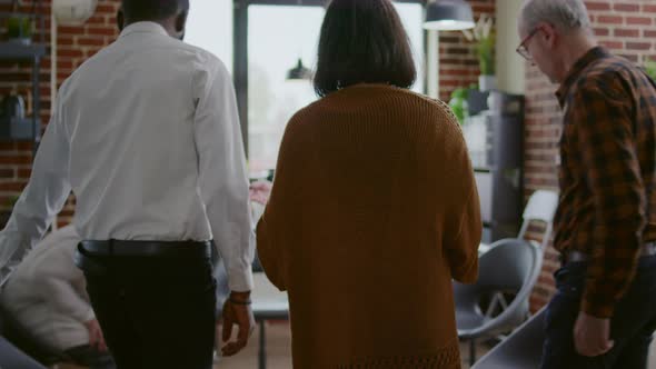 Multi Ethnic People with Alcohol Addiction Arriving at Aa Group Meeting with Therapist alt