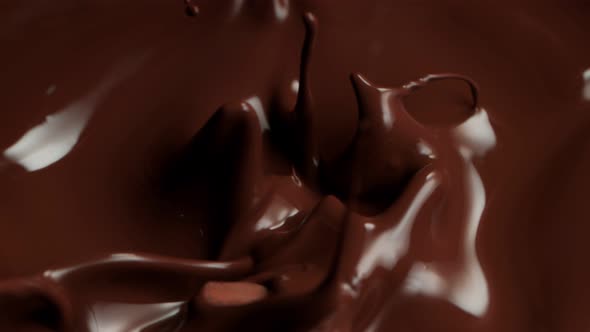 Super Slow Motion Shot of Raw Chocolate Chunks Falling Into Melted Chocolate at 1000Fps alt