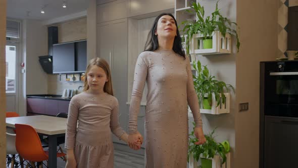 Confident Woman and Girl Holding Hands Walking in Expensive Furniture Store Looking Around Talking alt