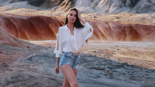 Beautiful woman posing on other-worldly hilly landscape