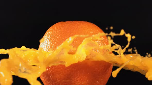 Fresh Orange Fruit Squirting and Burst with Juice in Slow Motion in Black Background alt