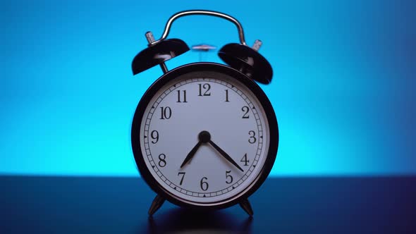 Black Alarm Clock on a Blue Background. 