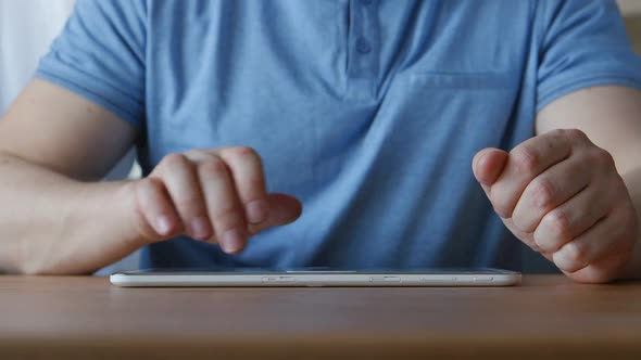 Hands Of Young Man Touching On A Tablet Pc At The Table At Home