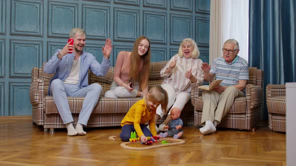 Happy Multigenerational Family Leisure at Home Couple Parents and Grandpagents Relaxing on Sofa alt