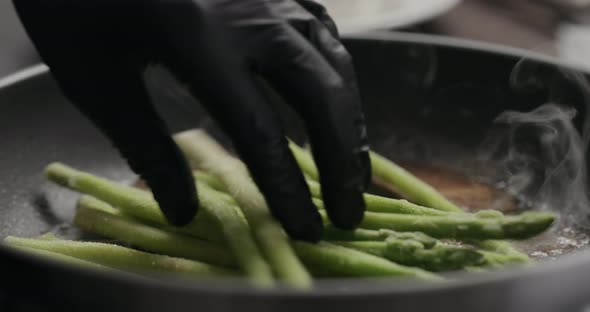 Slow Motion Closeup of Frozen Asparagus Put on Nonstick Pan alt