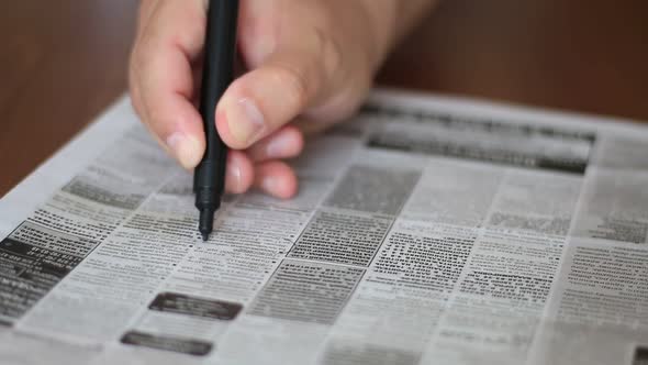 Man Highlighting The Advertisements In Newspaper With Marker