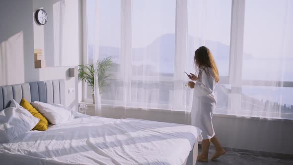 Woman Walks Past Panoramic Window in Hotel