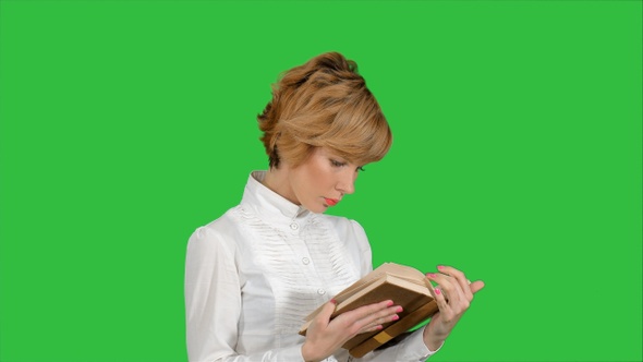 Concentrated young business woman holding and reading book