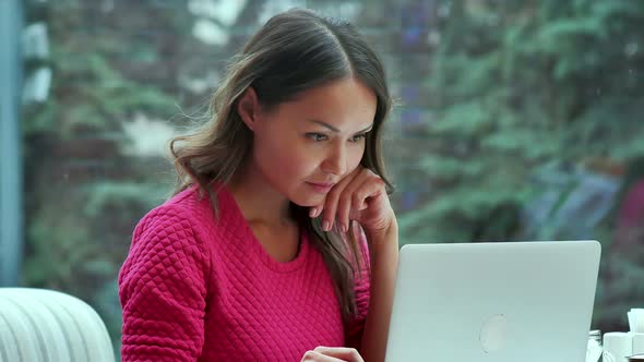 Millennial Young Woman Chat Online Using Laptop Computer in Cafe alt