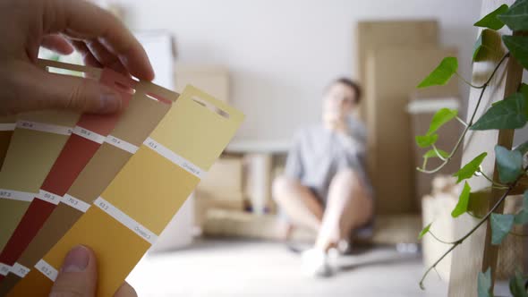 Woman Chooses Colors of Walls While Boyfriend Holds Palette