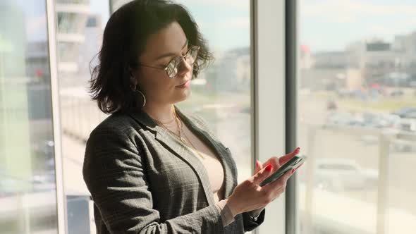Business woman using a mobile phone, texting, typing text messages, checking email alt