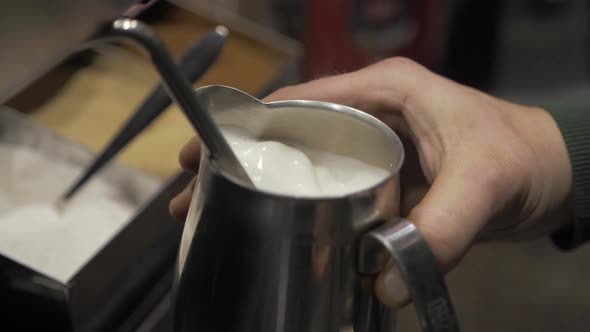 Cafe Worker Turning Off the Steam Frothing Machine After Preparing Milk for a Cappuccino. alt