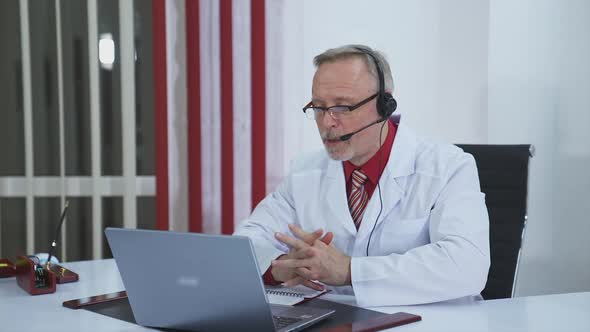 Doctor wear headset who is listening to patient and then talking about his symptom online. alt