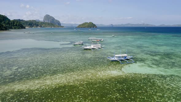 Aerial Drone View of Boats Anchored in Shallow Water Clear Emerald Green Lagoon alt