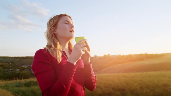 a Young Woman Happily Set Up a Tent on the Mountain Hills During Sunset for Rest After a Hike alt