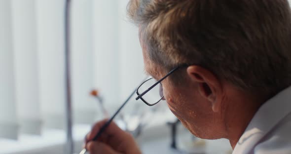 Closeup of Painting a Ceramic Dental Crown with a Thin Brush By Hand alt