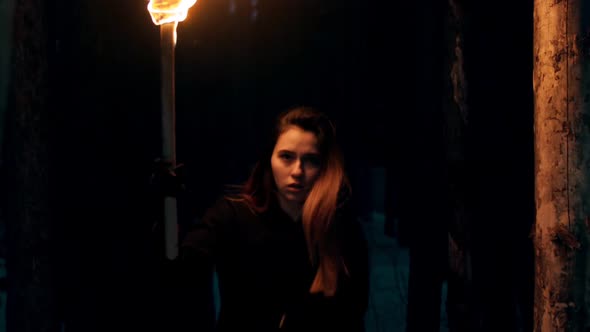 Young Pretty Woman Traveler Walking in the Woods at Night Time Holding a Torch alt