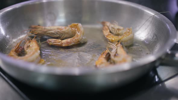 Closeup Frying Pan with Cooked Prawns in Oil Grilling Shaking in Slow Motion alt