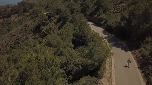 Flying above a young man skateboarding on the road