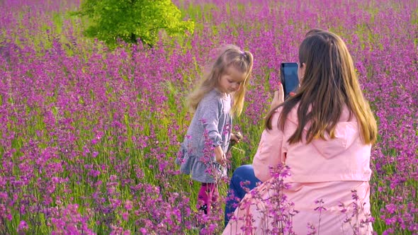 Woman Making Photo of Her Daughter in the Field