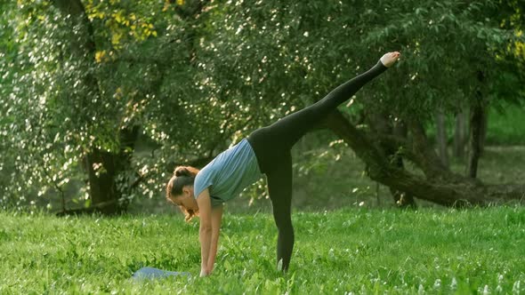 Woman Practices Yoga at Sunset in Park alt