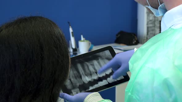 Dentist Shows the Patient X-ray on Tablet