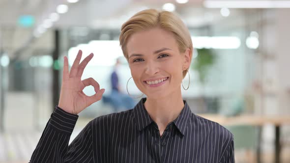 Appreciative Young Businesswoman Showing Ok Sign By Hand  alt