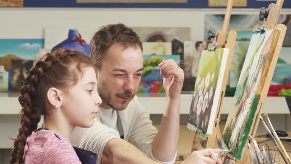 Mature Male Painter Artist Helping His Cute Daughter with a Painting alt