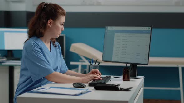 Nurse Typing on Computer Keyboard for Consultation alt