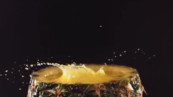 Pineapple Pieces Falling on the Surface of Half Pineapple in Slow Motion alt