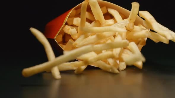 Close up of box with french fries falls on a table