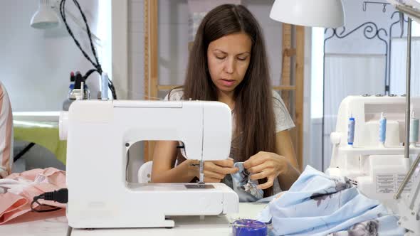 Seamstress at Work in Workshop Sewing Clothes on Sewing Machine alt