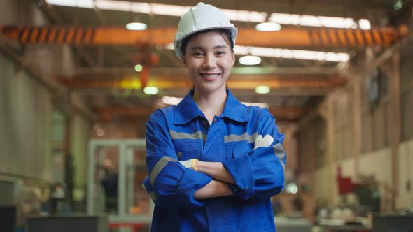 Portrait of Asian female industry worker working in factory warehouse.