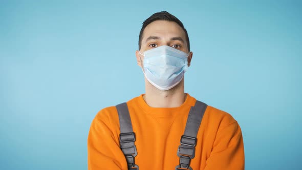 Male Handyman or Fixer Fixing Face Mask and Looking To the Side alt