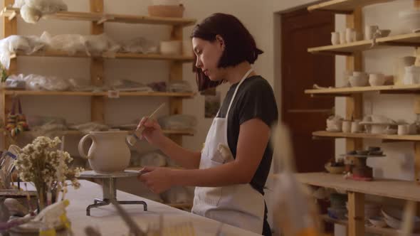 Young female potter working in her studio alt