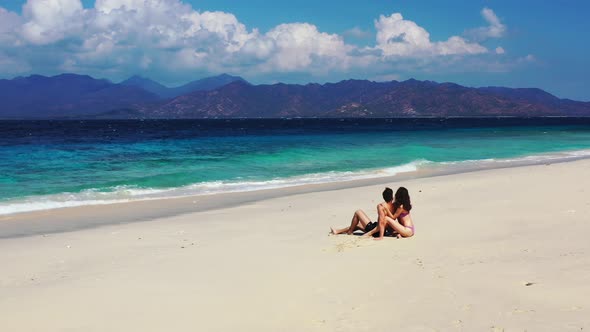 Happy lady and man in love dating on vacation have fun on beach on white sand 4K background alt
