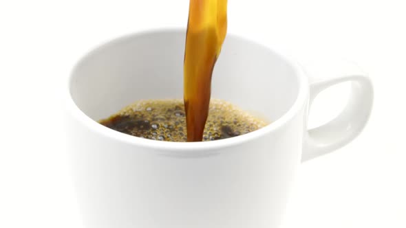 Jet of Black Hot Coffee Pouring Into Mug Slow Motion Isolated on White Backdrop