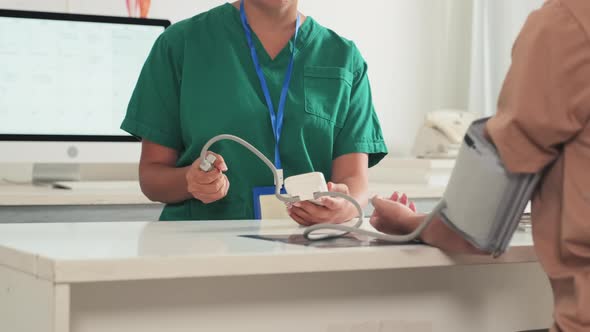 Doctor Checking Blood Pressure of Female Patient alt