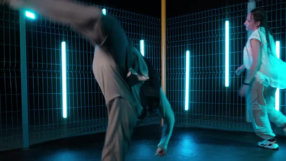 Duet of Dancers Performing Afro Dance at Night with Lightstands at Background alt