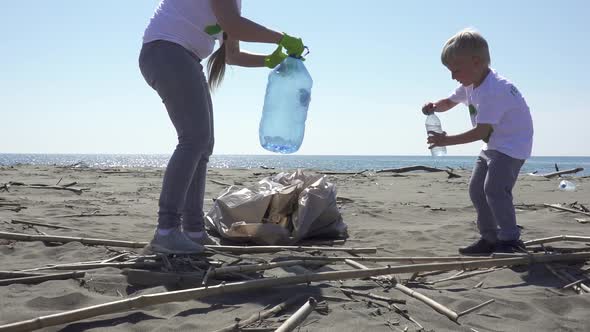 Family Picks Up Trash From the Beach in Trash Bags